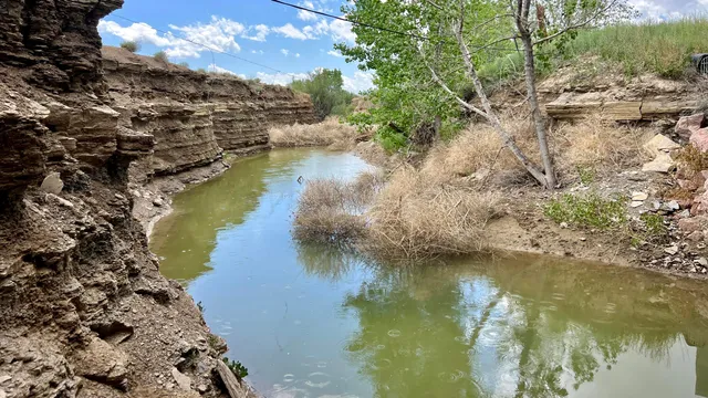 a view of a lake with lawn chairs