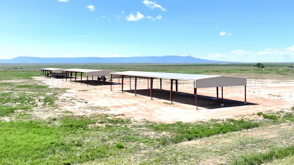 a view of a terrace with a table and chairs under an umbrella