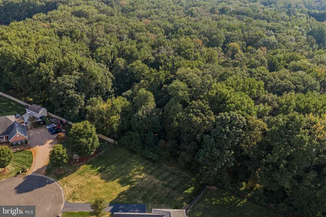 an aerial view of a house with a garden and lake view