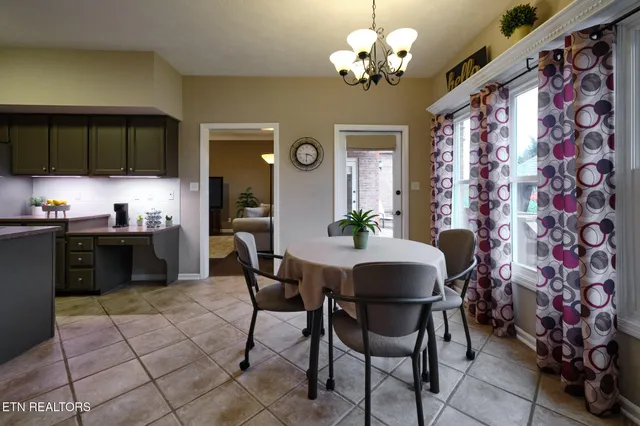 a dining room filled chandelier and kitchen view