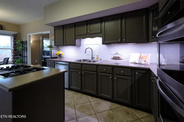 a kitchen with stainless steel appliances a sink stove and cabinets