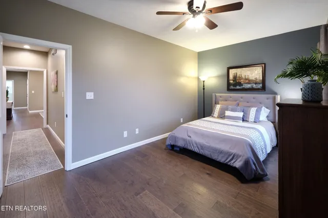a view of a hallway with wooden floor and a bathroom