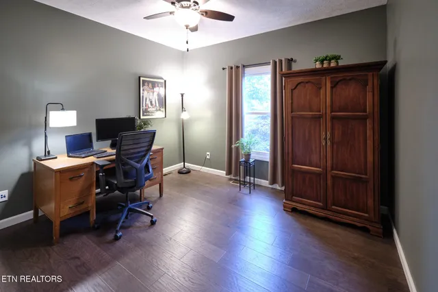a view of a workspace with furniture and a window