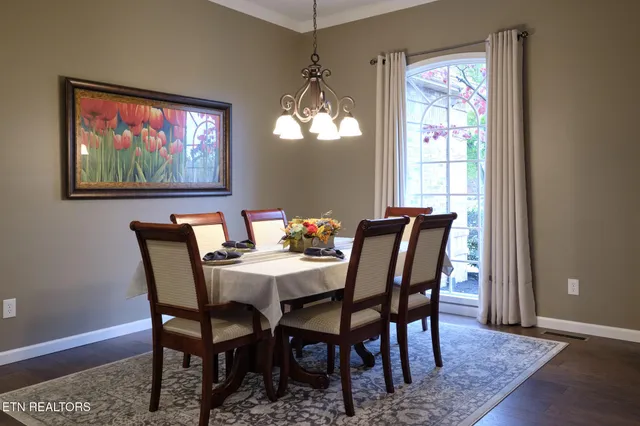 a dining room with furniture a rug and a chandelier