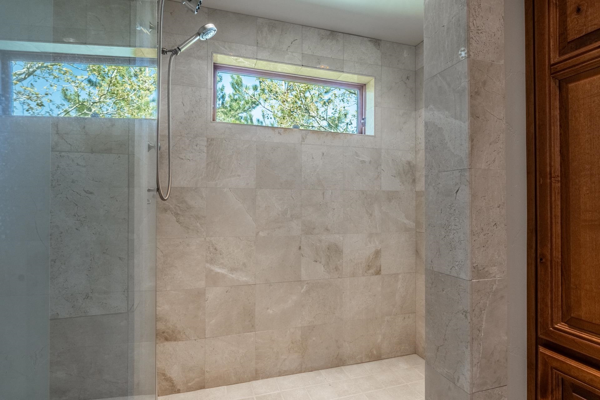 45 Skyline Road June Lake, CA 93529 - Photo 28 of 58 Walk-in shower with tiled walls and flooring, featuring a fixed showerhead and handheld sprayer