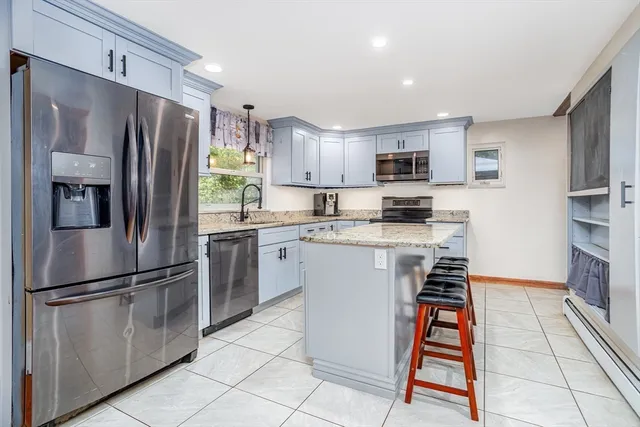 a kitchen with granite countertop kitchen island sink stove and refrigerator