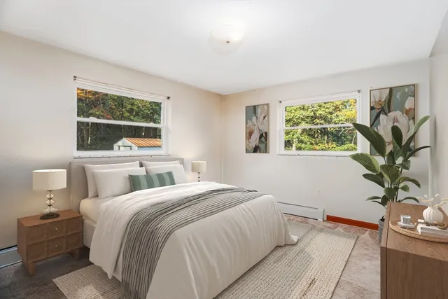 a bedroom with a large bed and a potted plant