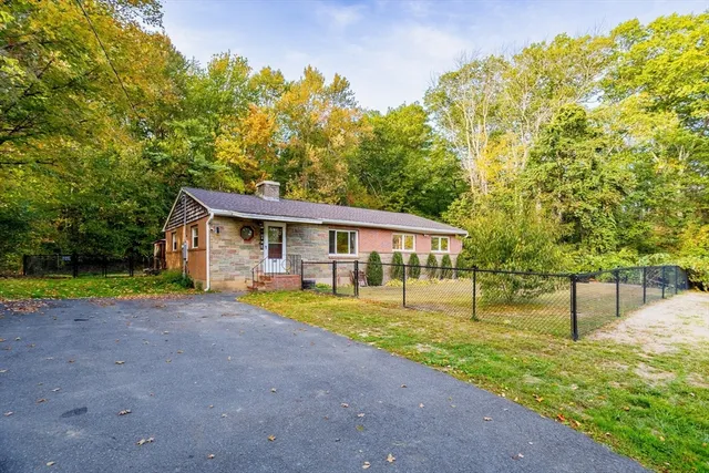 a view of a house with a yard and sitting area