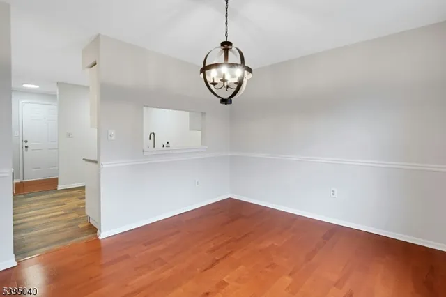 a view of a room with wooden floor and white walls