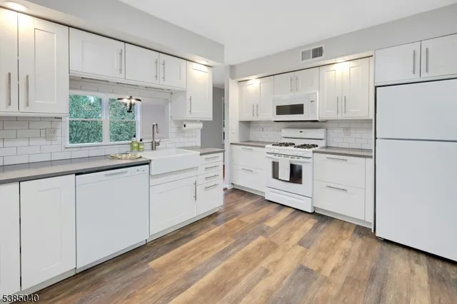 a kitchen with white cabinets and white appliances
