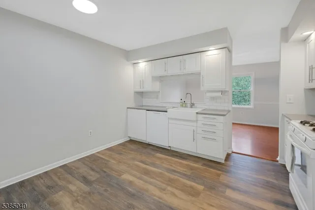 a kitchen with a sink cabinets and wooden floor