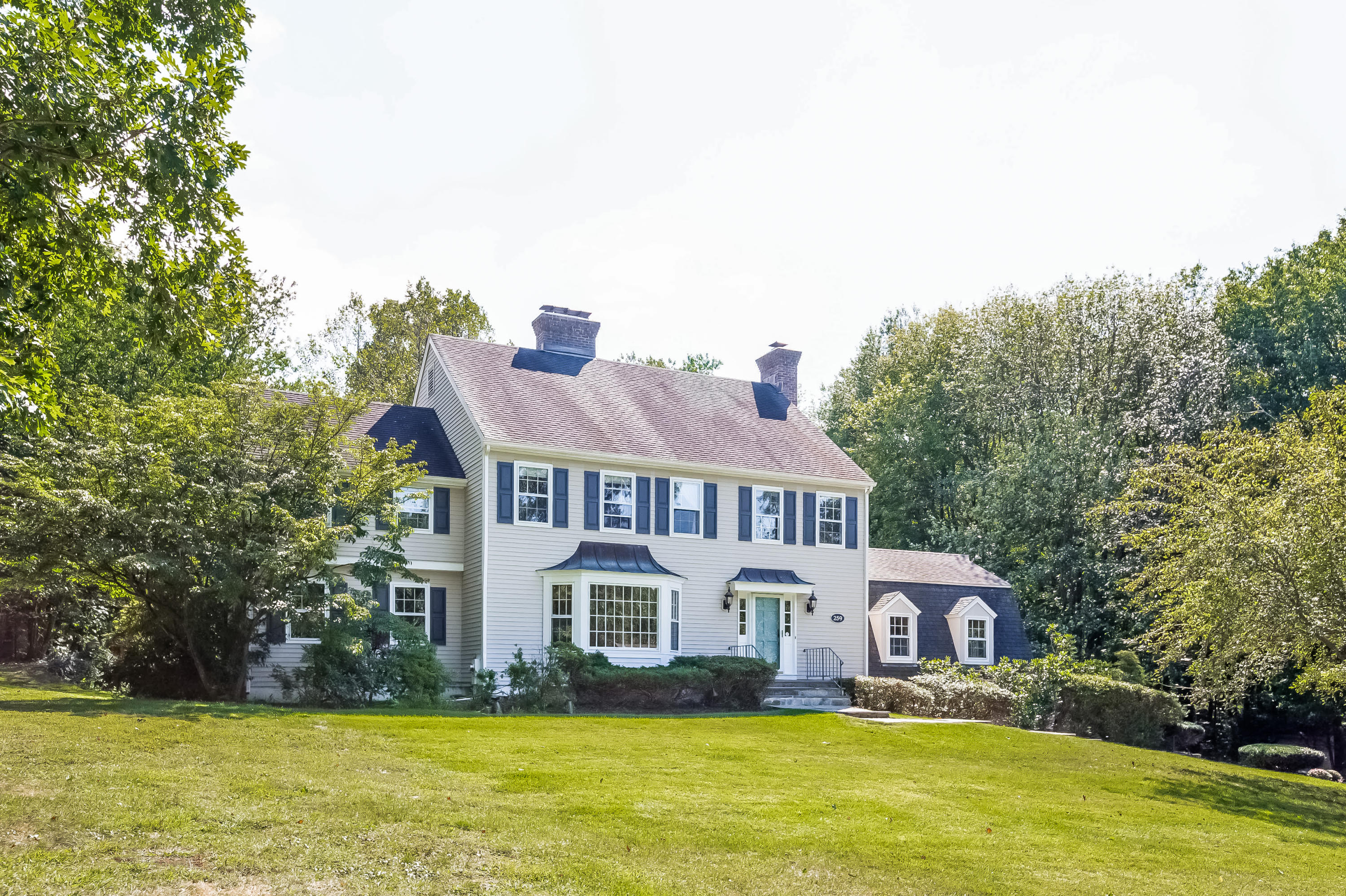 259 Marvin Ridge Road New Canaan, CT 06840 - Photo 38 of 38 a front view of a house with a garden and trees