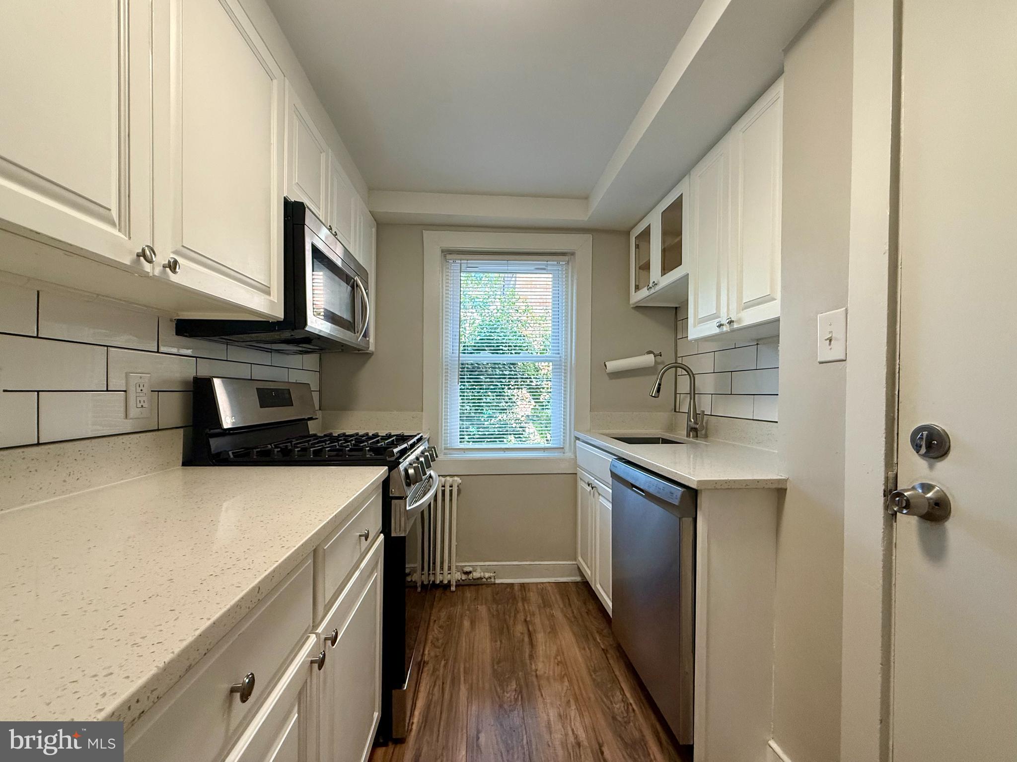 1400 Kenmore Avenue, Unit E1 Fredericksburg, VA 22401 - Photo 6 of 11 a kitchen with a sink a stove top oven and cabinetry