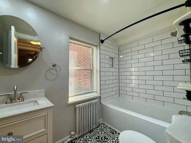 a bathroom with a bathtub a window and a shower