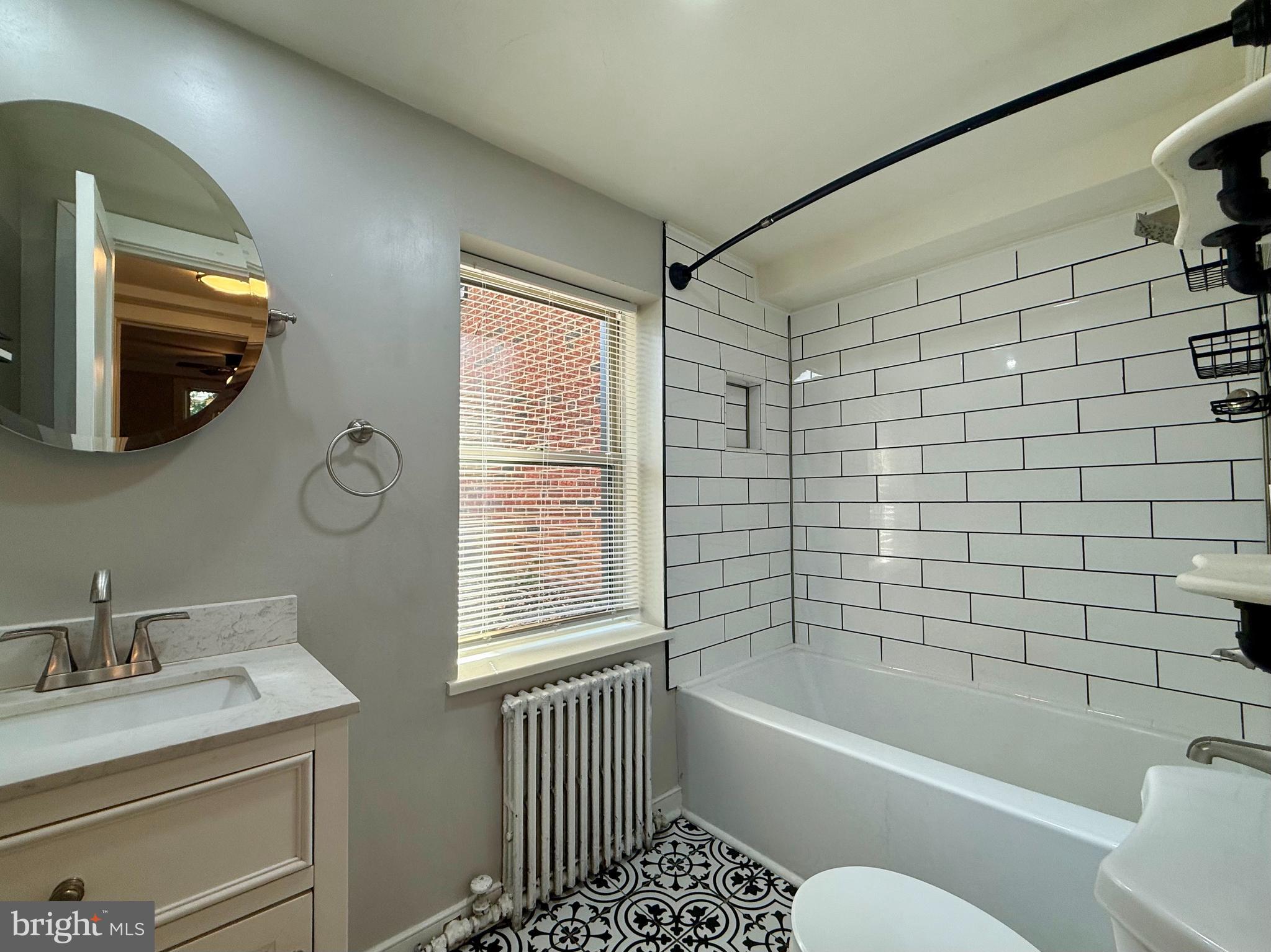 1400 Kenmore Avenue, Unit E1 Fredericksburg, VA 22401 - Photo 7 of 11 a bathroom with a bathtub a window and a shower
