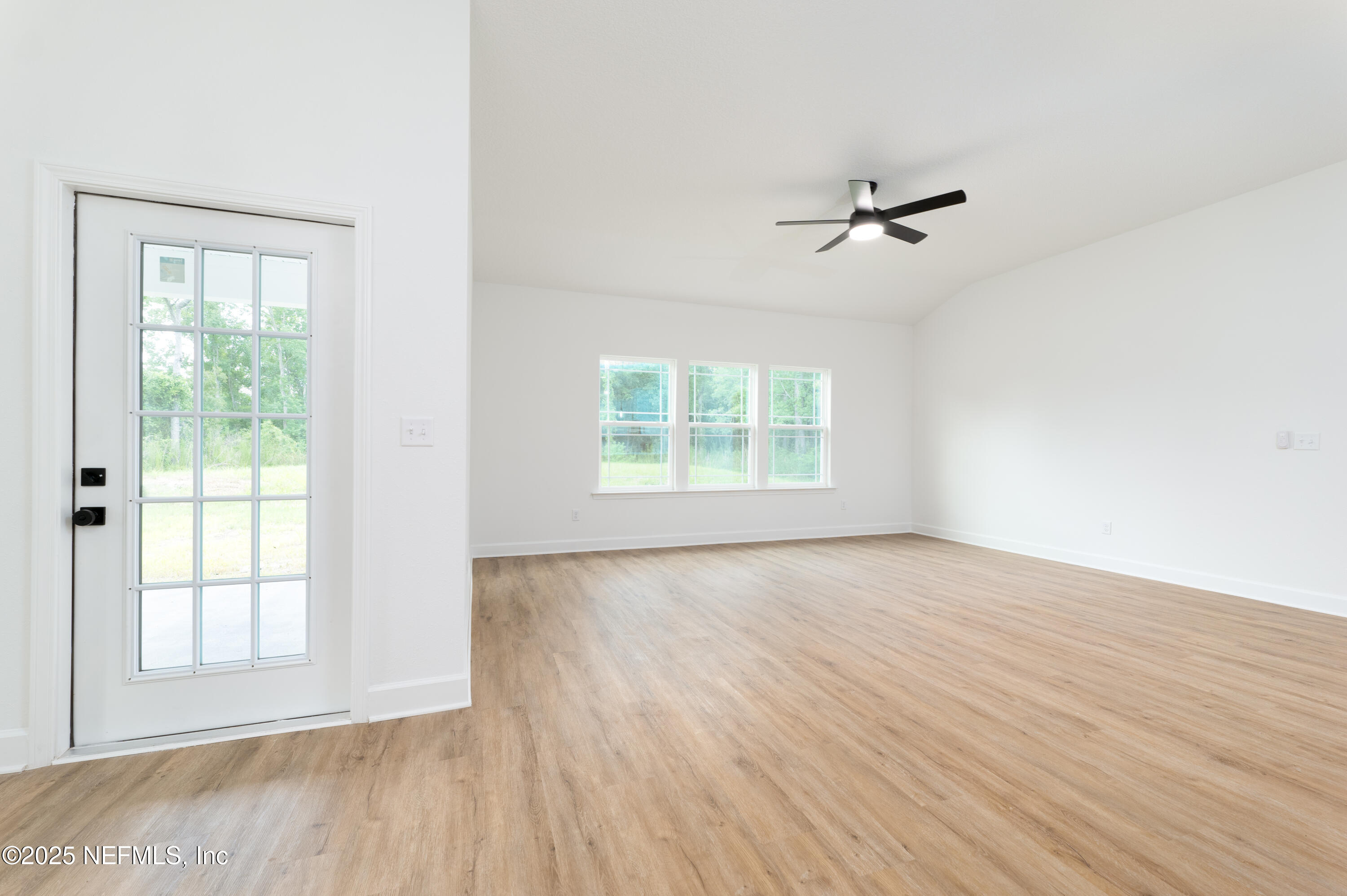 2482 Oleander Avenue Middleburg, FL 32068 - Photo 16 of 34 an empty room with wooden floor ceiling fan and windows
