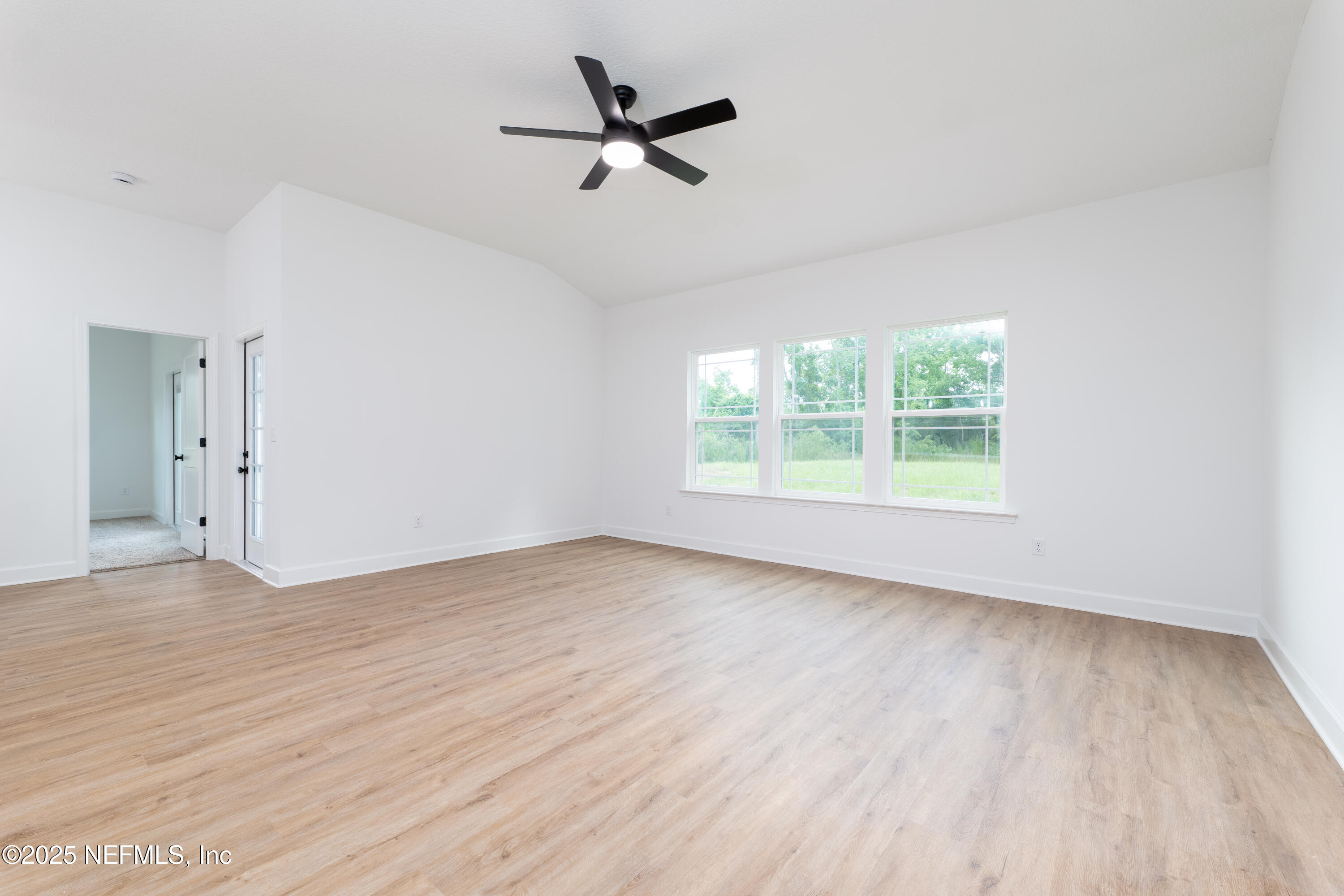 2482 Oleander Avenue Middleburg, FL 32068 - Photo 22 of 34 an empty room with wooden floor ceiling fan and windows