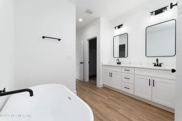 a spacious bathroom with a double vanity sink and mirror