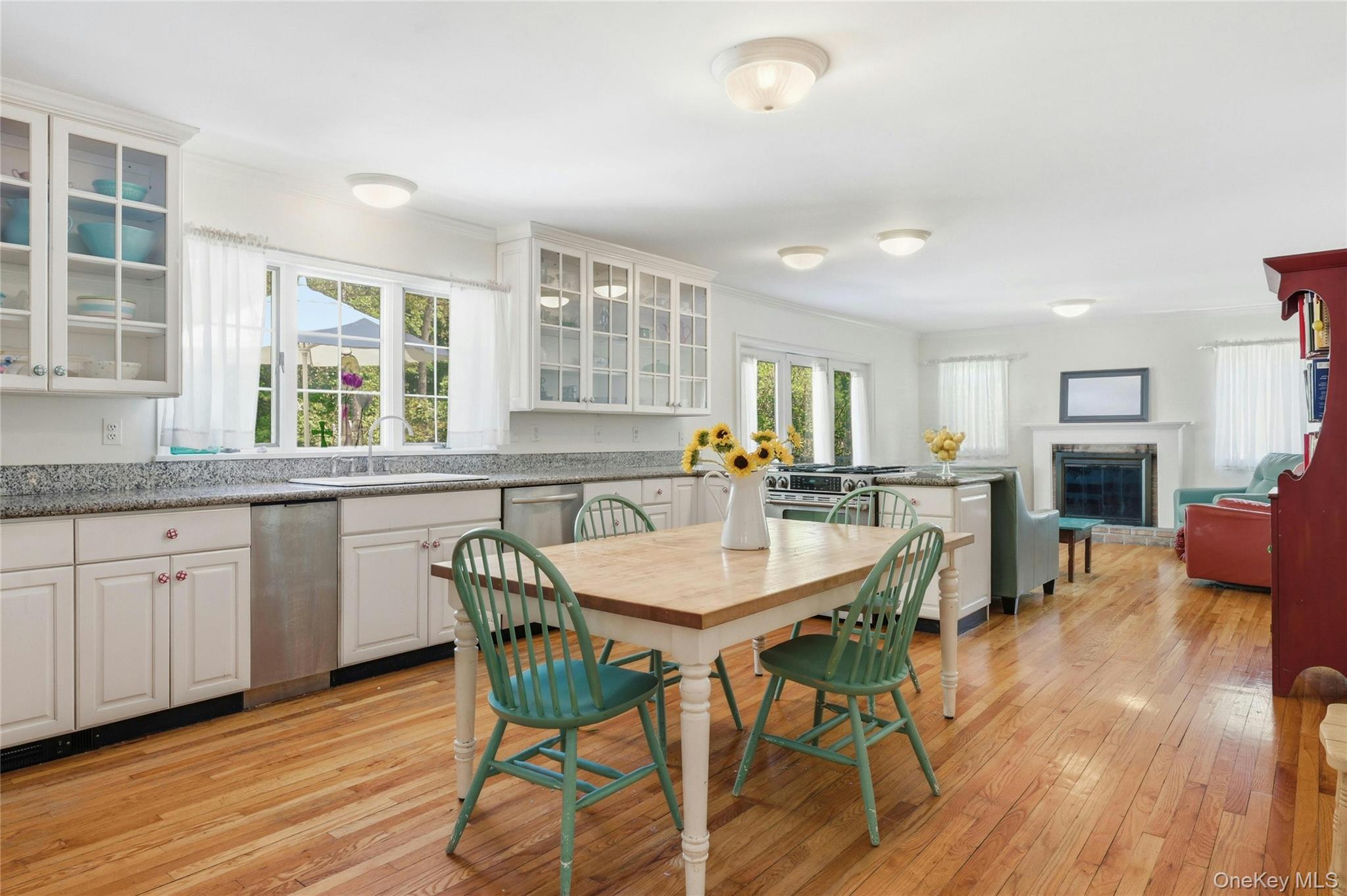 9 Townsend Road Glen Cove, NY 11542 - Photo 20 of 48 a open dining room with stainless steel appliances granite countertop a stove a sink a refrigerator a dining table and chairs with wooden floor