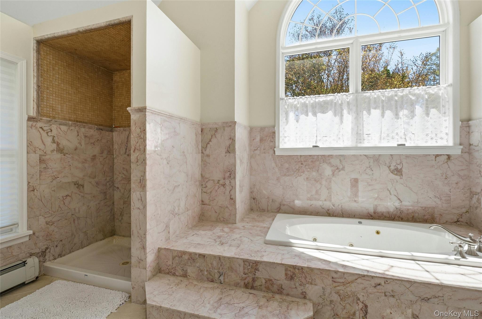 9 Townsend Road Glen Cove, NY 11542 - Photo 30 of 48 a bathroom with a tub a window and a glass door shower