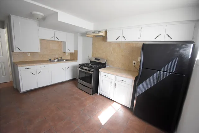 a kitchen with stainless steel appliances a stove a sink and a refrigerator