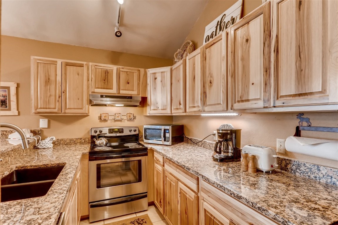 1937 Soda Ridge Road, Unit 1126 Keystone, CO 80435 - Photo 15 of 41 a kitchen with granite countertop a sink a stove and cabinets