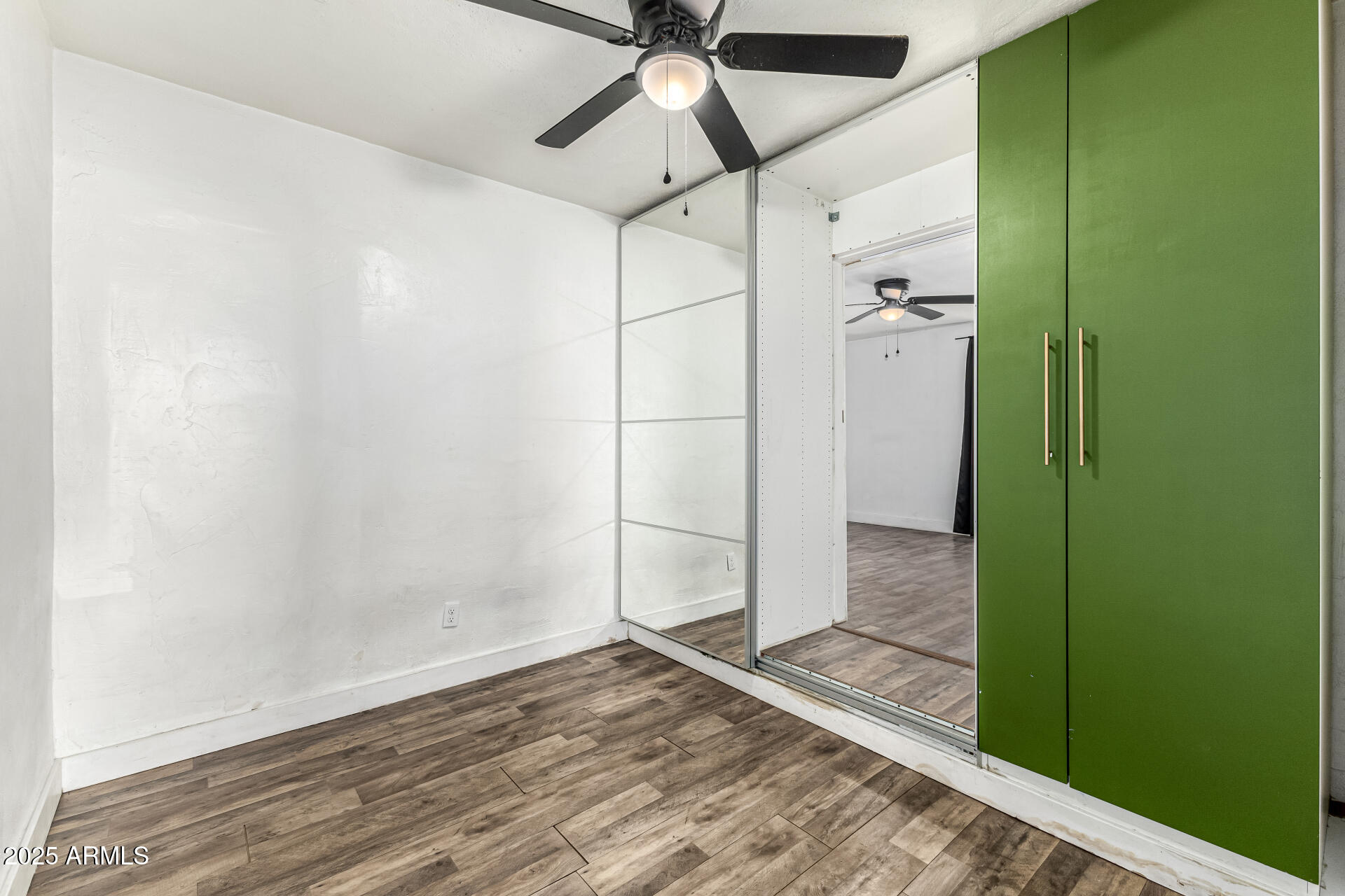 2811 West Pima Street Phoenix, AZ 85009 - Photo 14 of 24 a view of empty room with wooden floor and fan