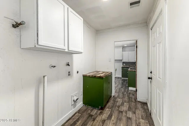 a kitchen with a refrigerator and a wooden floor