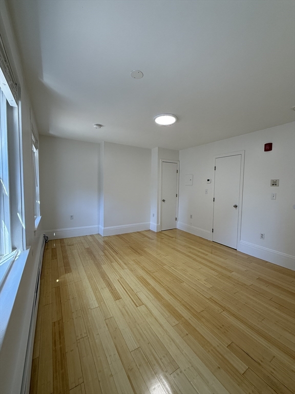 4 Milford Street, Unit M02 Boston, MA 02118 - Photo 2 of 9 a view of empty room with wooden floor