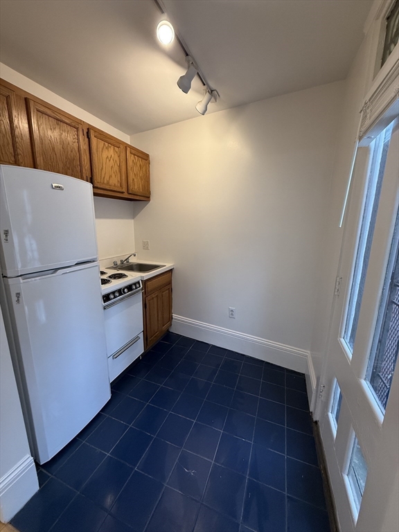 4 Milford Street, Unit M02 Boston, MA 02118 - Photo 5 of 9 a kitchen with a refrigerator sink stove and cabinets