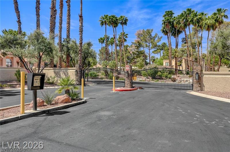 5370 Runningbrook Road Las Vegas, NV 89120 - Photo 26 of 30 Secure community entrance with an elegant wrought iron gate and lush landscaping.