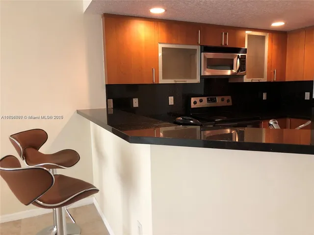 a kitchen with stainless steel appliances kitchen island a stove and a microwave