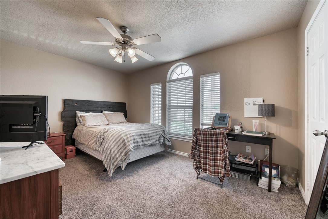 2327 Autumn Chase Loop College Station, TX 77840 - Photo 8 of 12 a bedroom with a bed and a chandelier