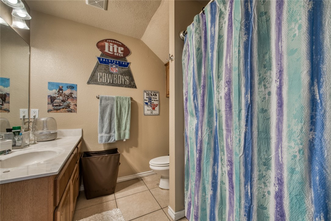 2327 Autumn Chase Loop College Station, TX 77840 - Photo 9 of 12 a bathroom with a sink a toilet and shower curtain