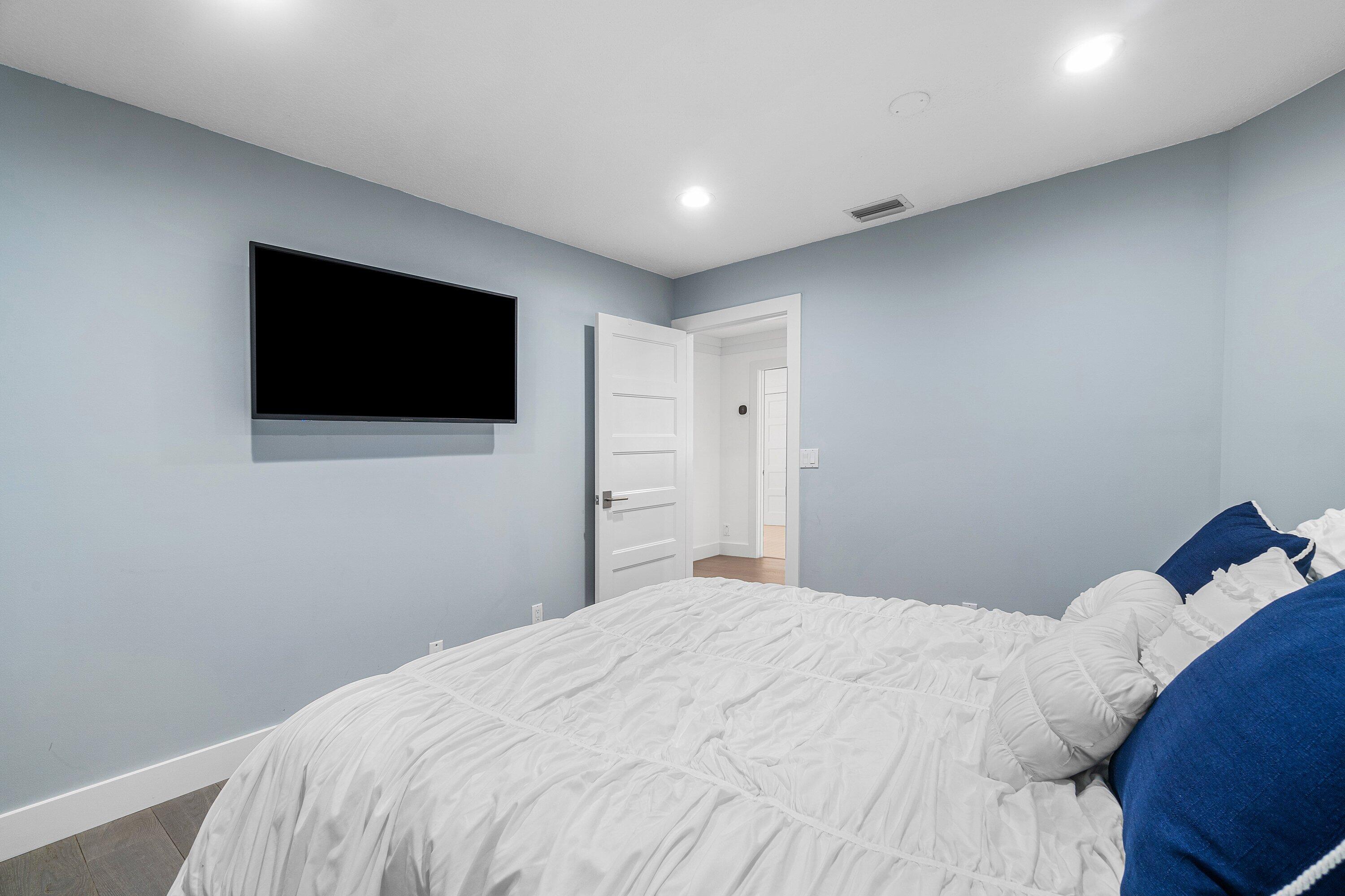 2404 Northwest 67th Street Boca Raton, FL 33496 - Photo 31 of 74 a bedroom with a bed and a flat screen tv