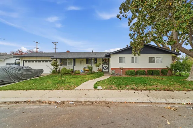 a view of a house next to a yard with a large tree