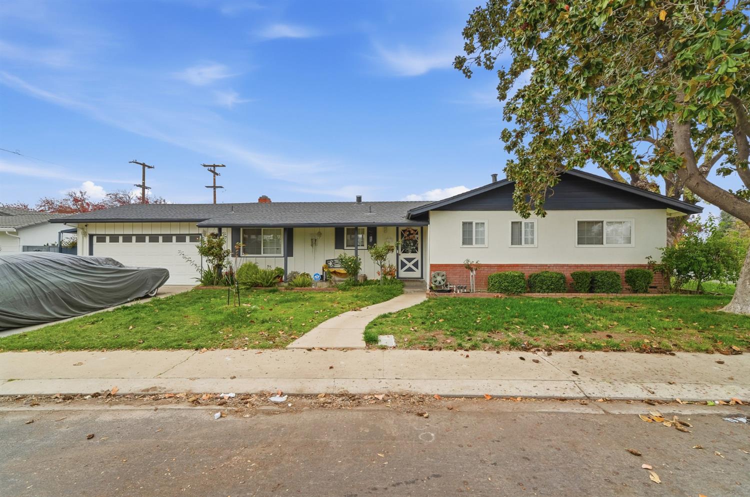 a view of a house next to a yard with a large tree