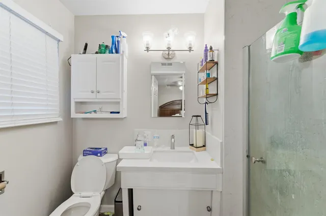 a bathroom with a sink vanity mirror and toilet