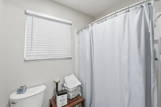 a bathroom with a sink a toilet and shower curtain