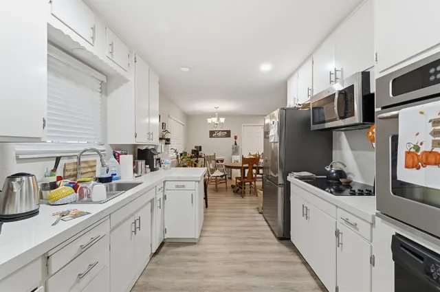 a kitchen with stainless steel appliances a sink a stove top oven a counter space and cabinets