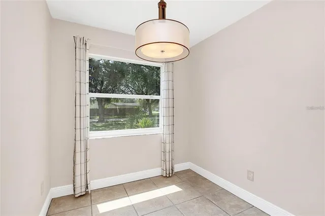 an empty room with a window and a potted plant