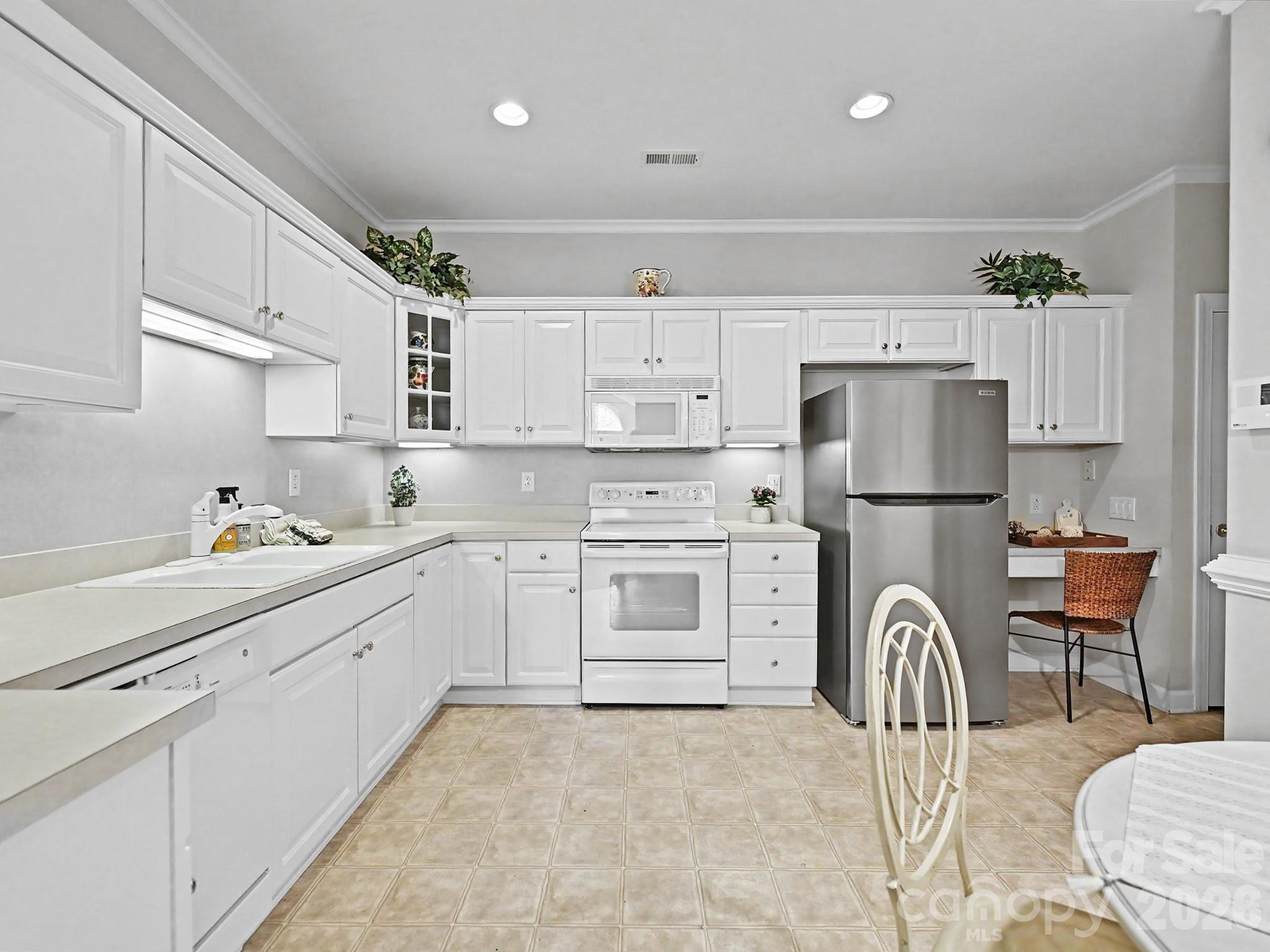 8655 Windsor Ridge Drive Charlotte, NC 28277 - Photo 9 of 22 a kitchen with white cabinets and stainless steel appliances