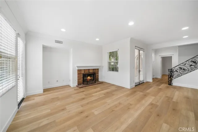 a view of an empty room with a fireplace and a window