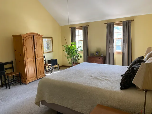 a bedroom with a bed chair and a window