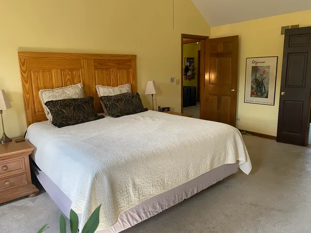 a large bed sitting in a bedroom next to a window