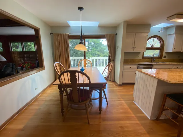 a dining room with furniture a chandelier and wooden floor