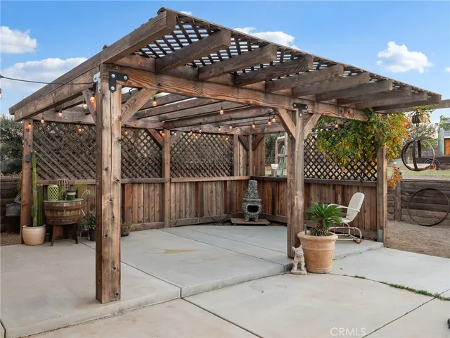 a view of a patio with table and chairs with wooden floor and fence