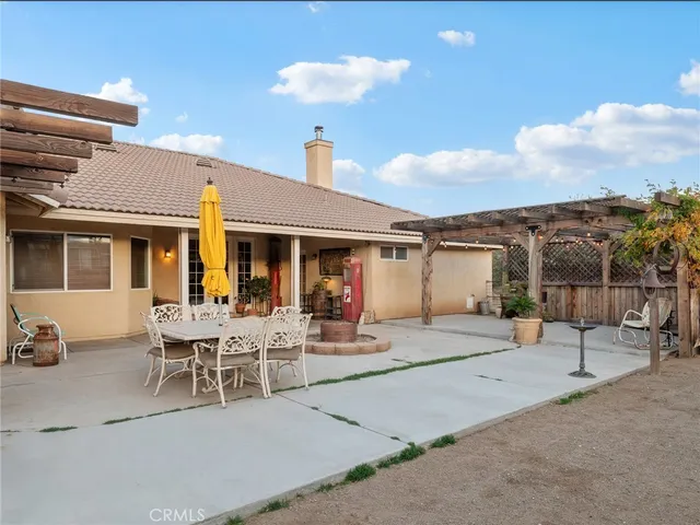 a roof deck with table and chairs and potted plants