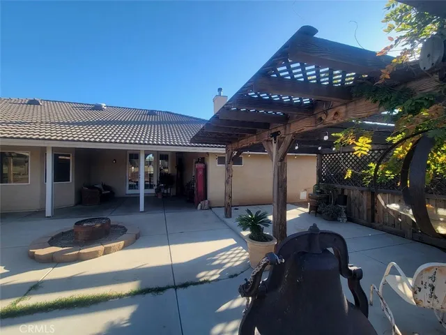 a view of a white house next to a yard with a large tree