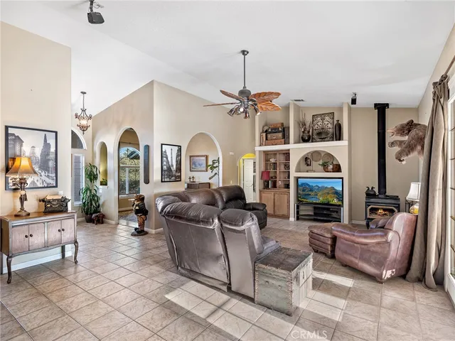 a living room with furniture kitchen view and a large window
